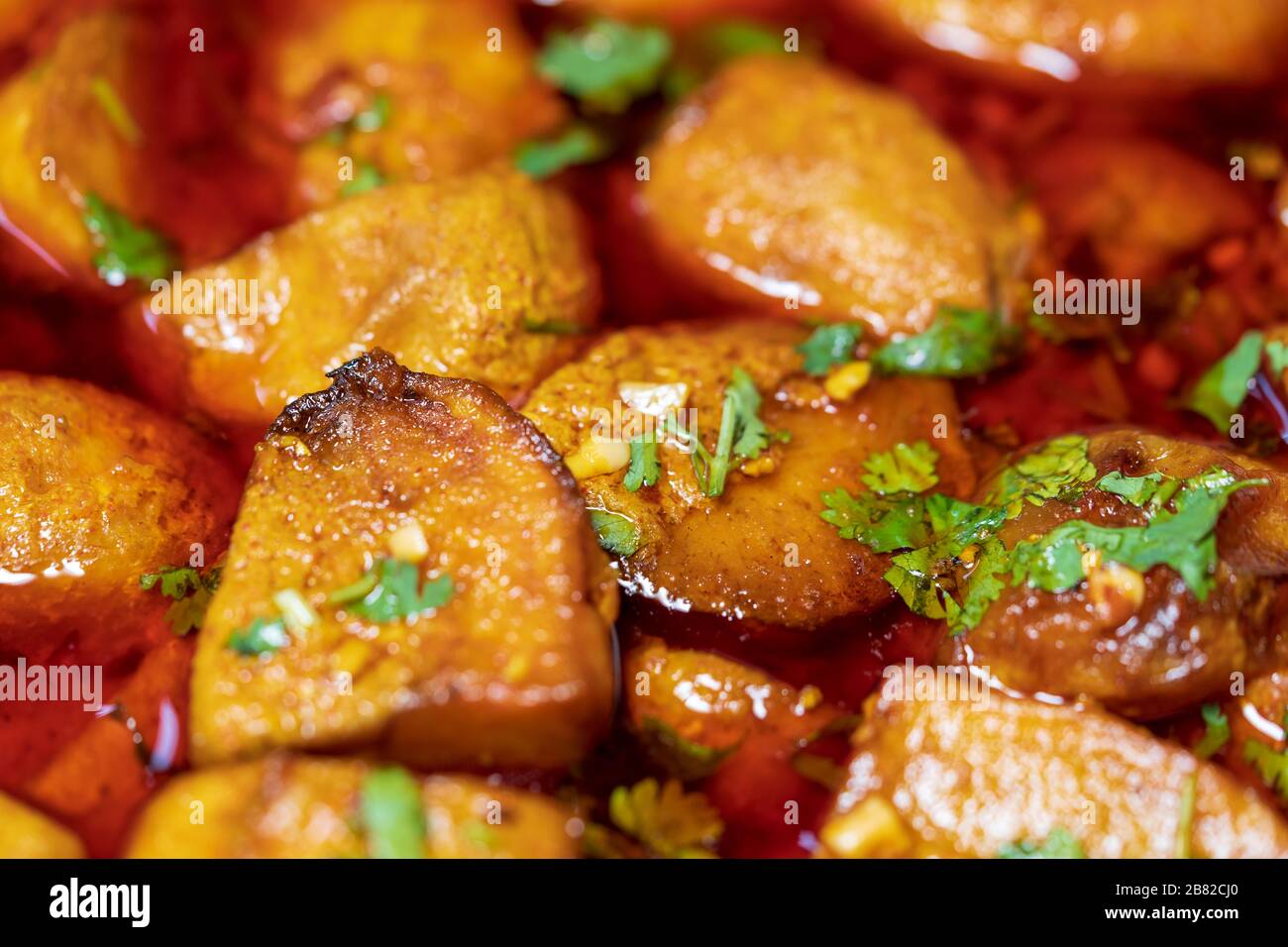 Dum Aloo - piatto indiano vegetariano con patate, cotto lentamente in cipolla di pomodoro, salsa piccante di peperoncino rosso. Shot di closeup piatto. Concetto per cuis indiano Foto Stock