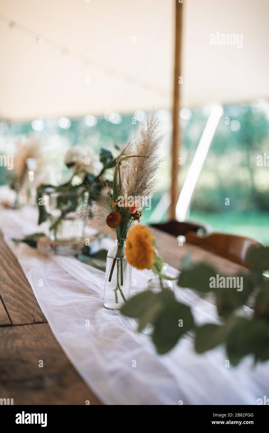 Decorazioni rustiche da tavolo all'aperto. Bouquet di fiori, fiori  selvatici secchi in vasi di vetro