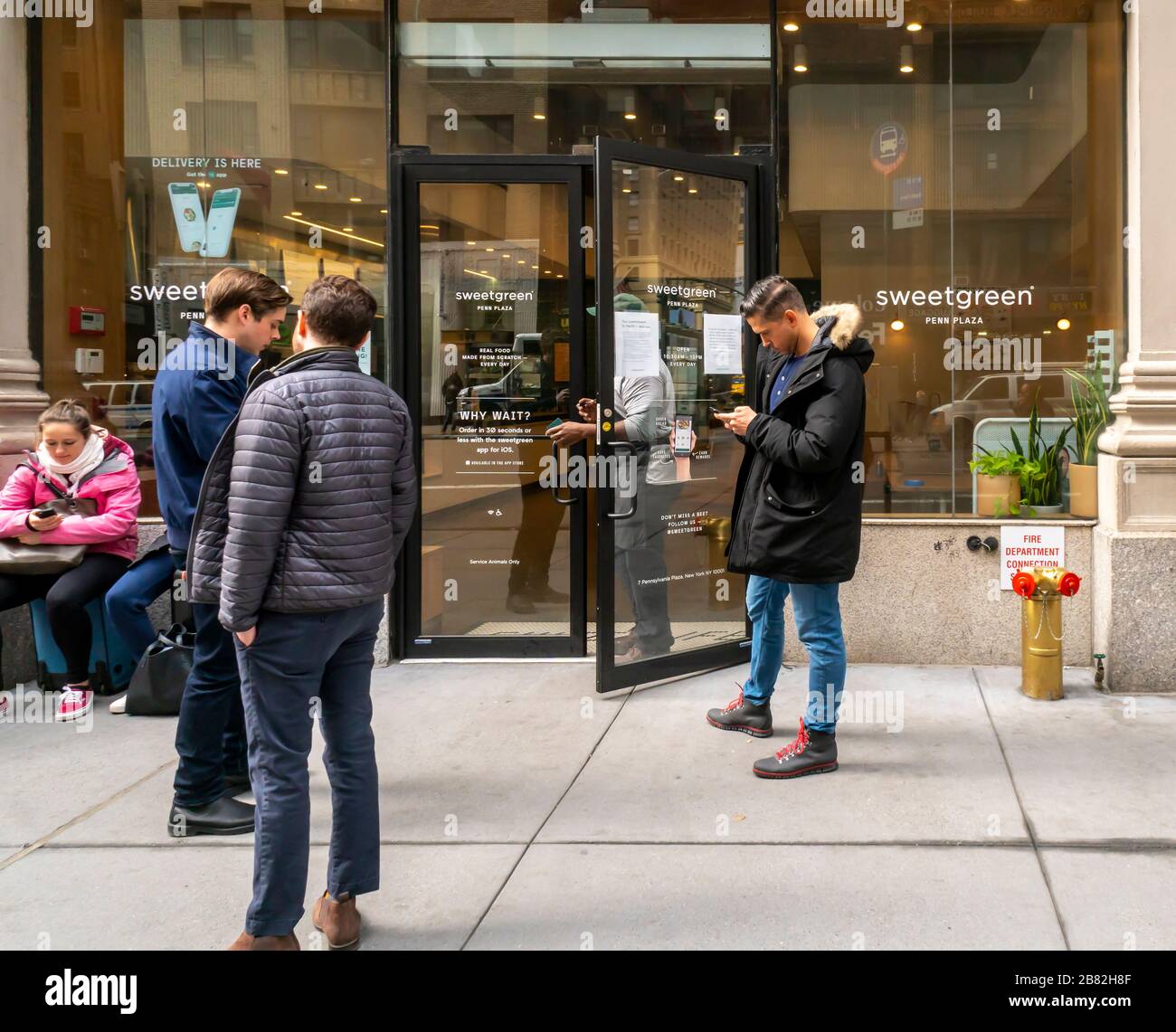 I clienti attendono i loro ordini al di fuori di un ristorante Sweetgreen a New York martedì 17 marzo 2020. A causa del requisito di distanza sociale bar e ristoranti sono chiusi con ristoranti autorizzati solo a fare il take-out e la consegna. (© Richard B. Levine) Foto Stock