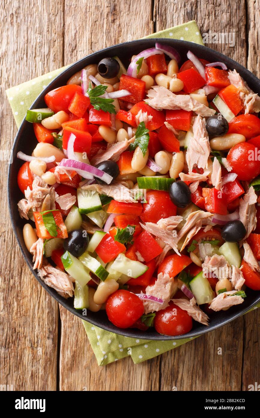 Insalata di tonno mediterranea con verdure fresche e fagioli primo piano in un piatto sulla tavola. Vista verticale dall'alto Foto Stock