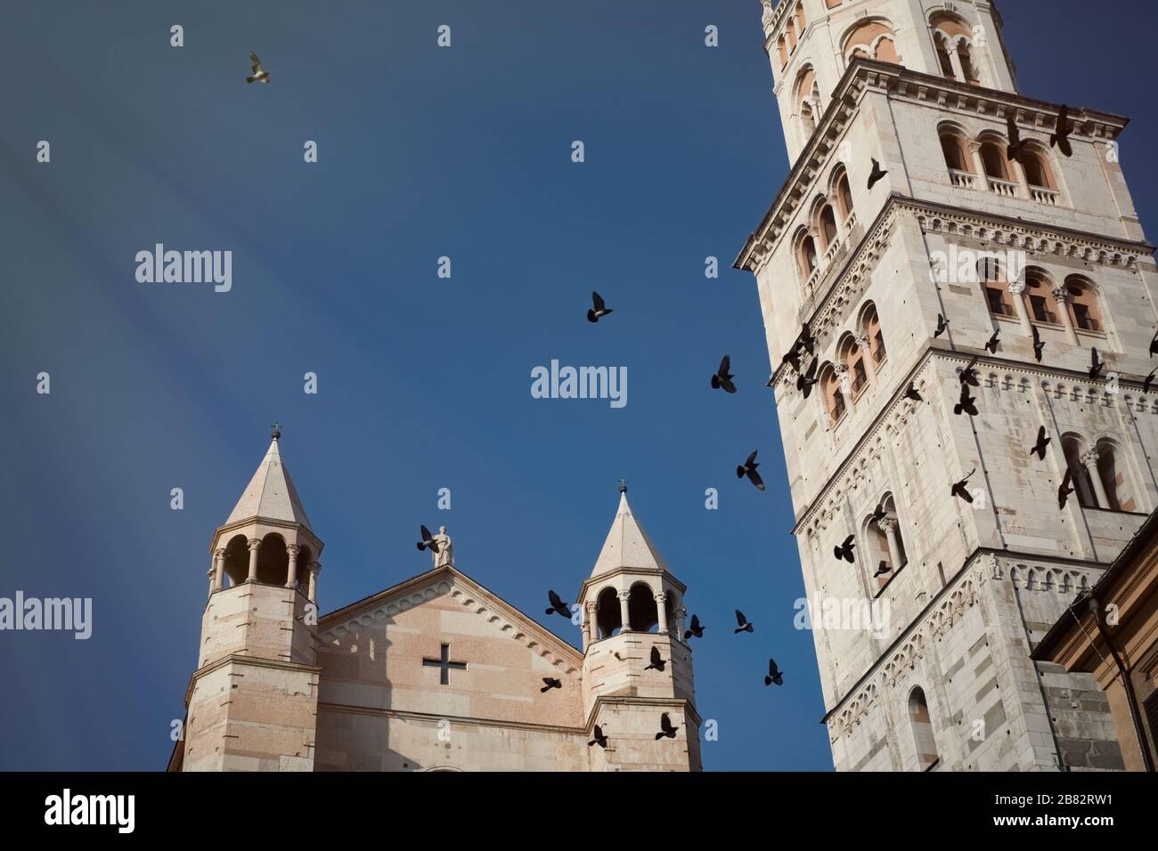 Campanile della cattedrale con piccioni in volo a Modena, Italia Foto Stock