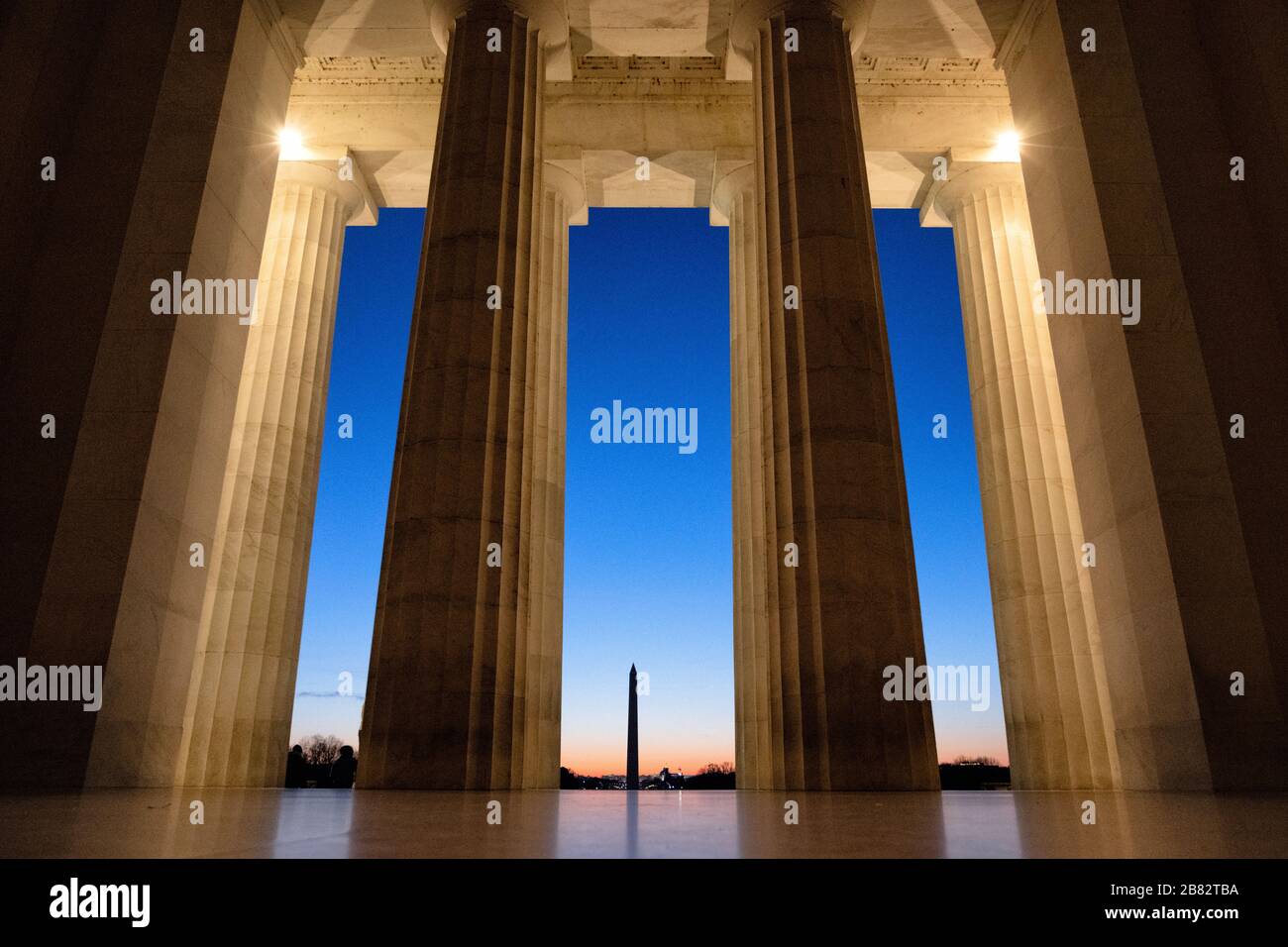 Lincoln Memorial View of Washington Monument Washington DC // WASHINGTON DC - Una vista dall'interno della camera principale del Lincoln Memorial, guardando attraverso le enormi colonne verso il Washington Monument poco prima dell'alba. Foto Stock