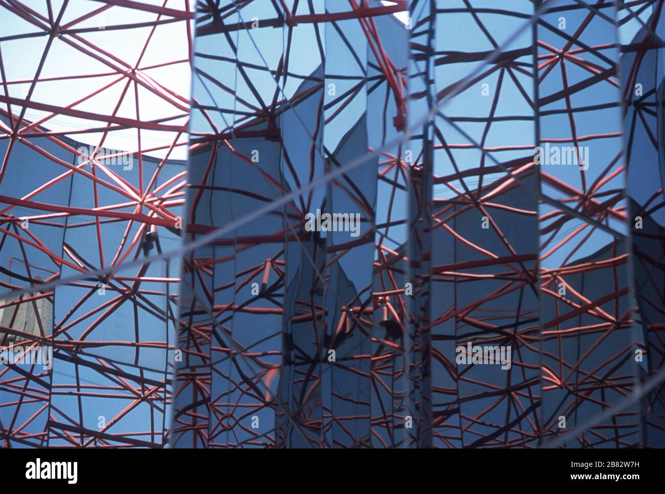 Riflessioni e struttura. Una struttura in acciaio verniciato di colore rosso che si riflette nei pannelli di vetro blu e colorato sul tetto dell'hotel Parador a Ronda, provincia di Malaga, Andalusia, Spagna. Foto Stock