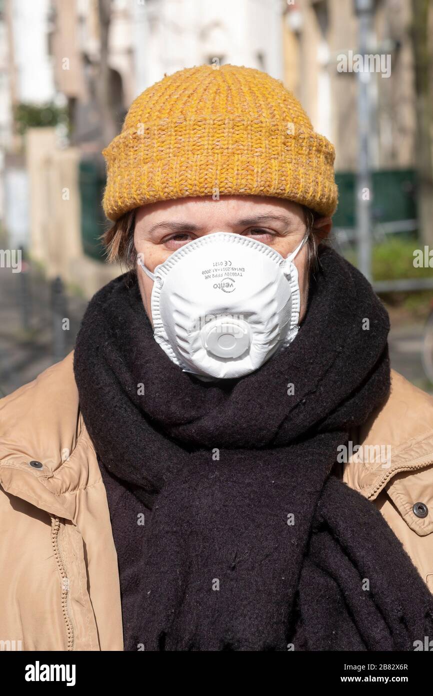 Passer-by con maschera respiratoria nel quartiere Nippes di Colonia Foto Stock
