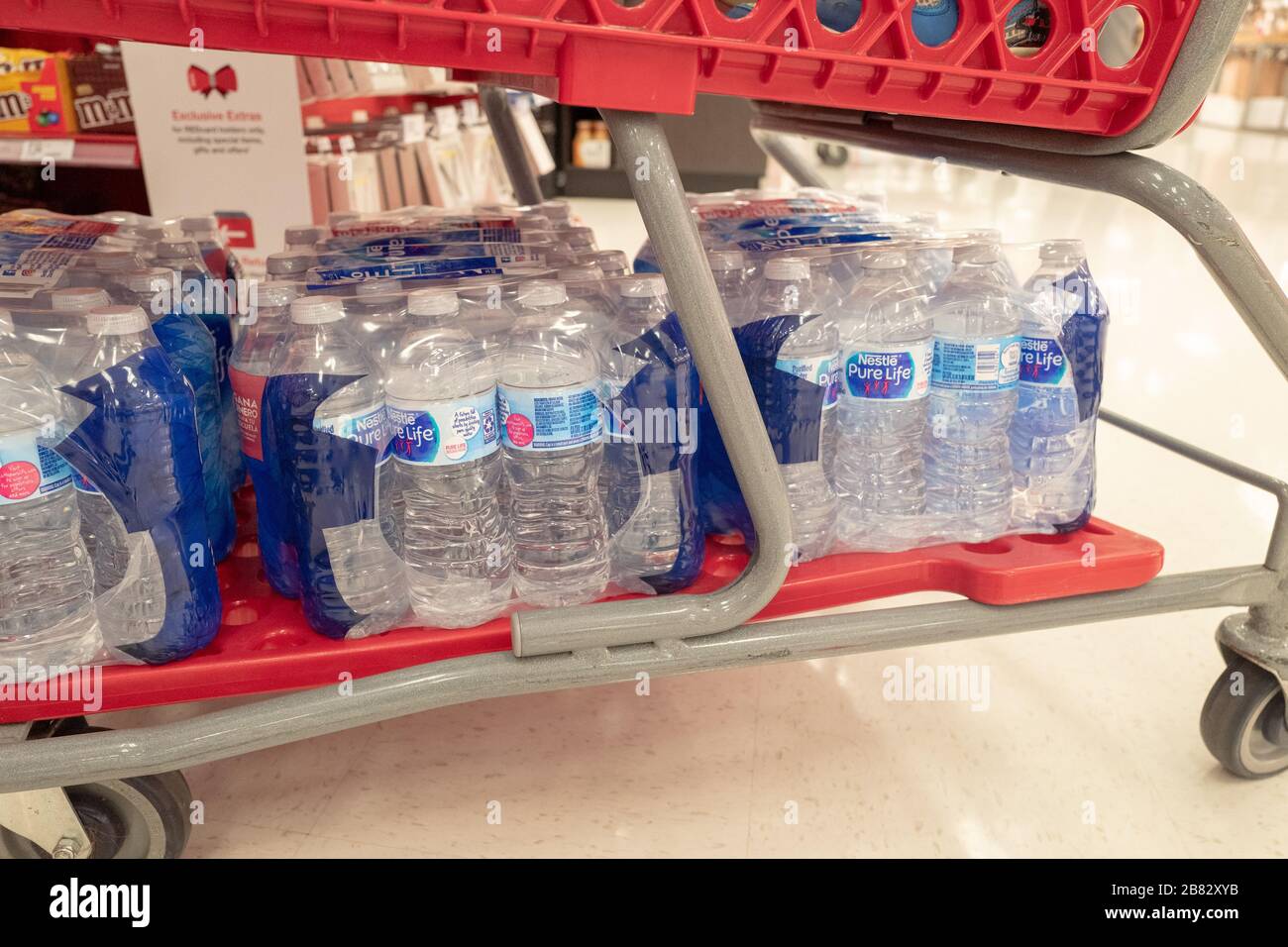 Diversi casi di acqua in bottiglia sono visibili sotto un carrello mentre i residenti si riforniscono di forniture presso un negozio Target nella Contra Costa County, San Ramon, California, durante uno scoppio del coronavirus COVID-19, 12 marzo 2020. () Foto Stock
