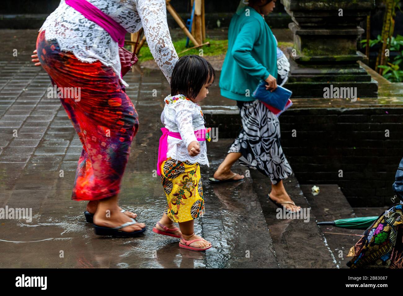 Il popolo indù balinese arriva alla cerimonia di Batara Turun Kabeh sotto la pioggia, al tempio di Besakih, Bali, Indonesia. Foto Stock