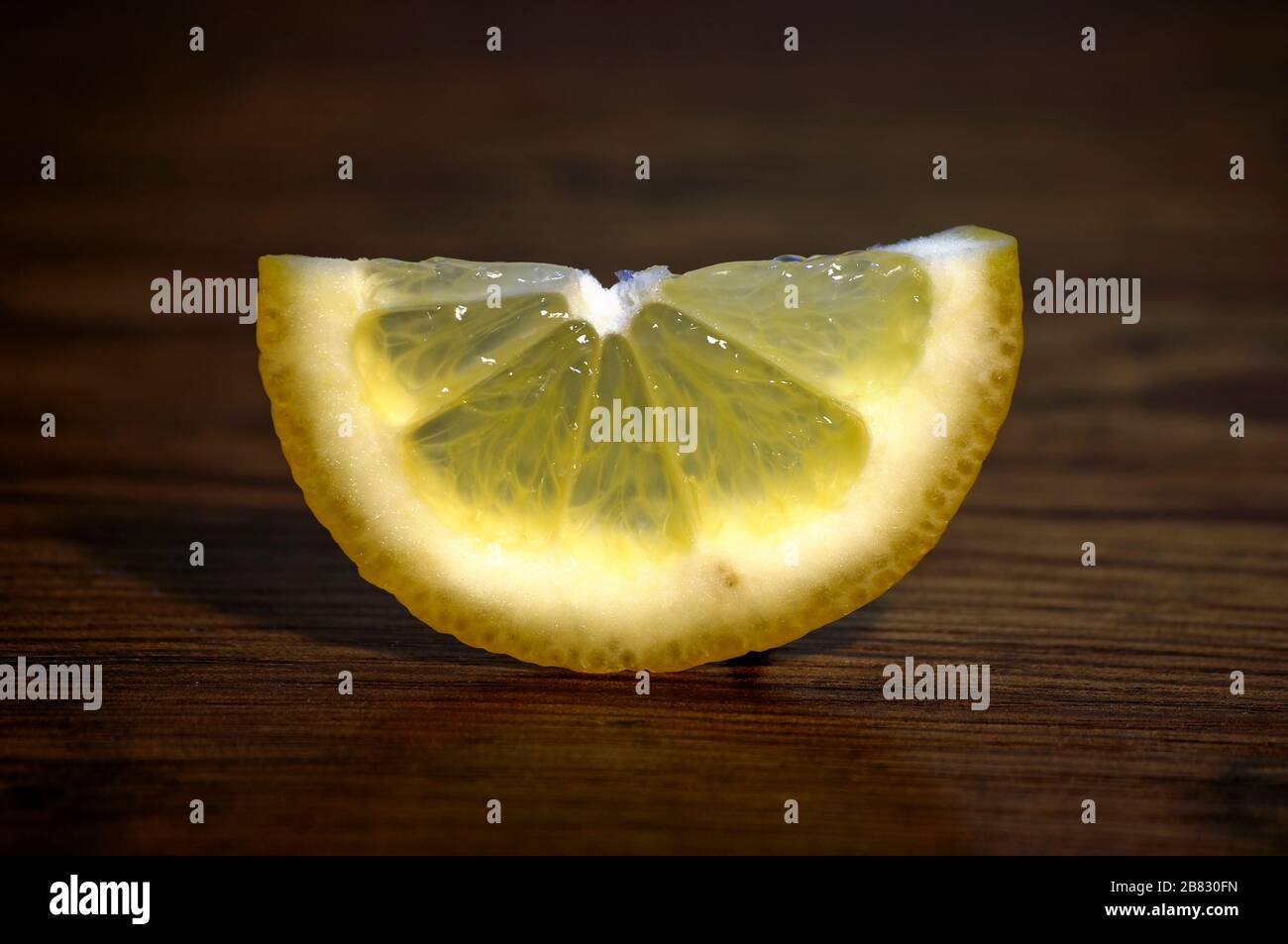 Ancora vita di un limone tagliato in un cuneo. Ecologico e stagionale. Foto Stock