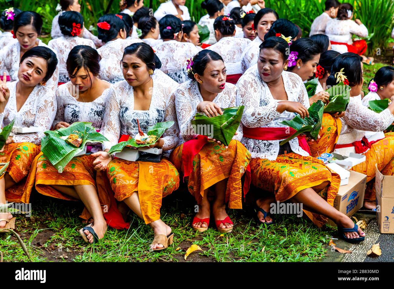 Un gruppo di donne in costume tradizionale mangiare pranzo durante UN festival indù, Tirta Empul Water Temple, Bali, Indonesia. Foto Stock