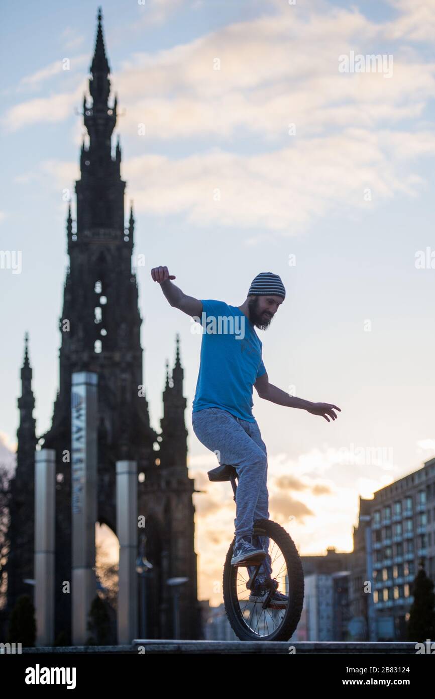 Edimburgo, Regno Unito. 19 Mar 2020. Nella foto: Andrew Buchan, una stunt e un estremo unicista passa il tempo durante quella che normalmente sarebbe un'ora di punta a Edimburgo, ma a causa della pandemia di Coronavirus il centro della città è estremamente tranquillo. La gente ora è affrontata con fare le cose differenti con il loro tempo durante l'isolamento di auto. Lo Scott Monument si trova sullo sfondo, un importante punto di riferimento di Edimburgo. Credit: Colin Fisher/Alamy Live News Foto Stock