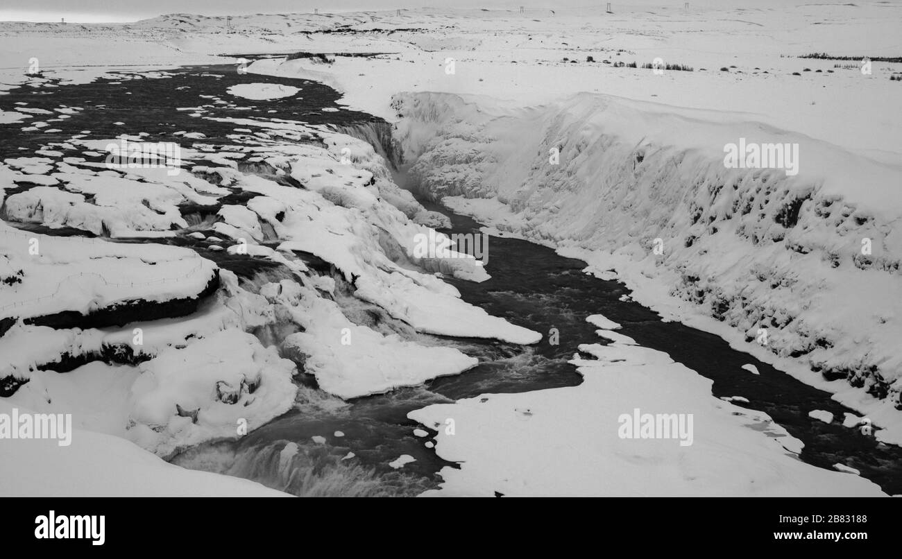 brook correre nella natura selvaggia islandese, paesaggio coperto di neve Foto Stock