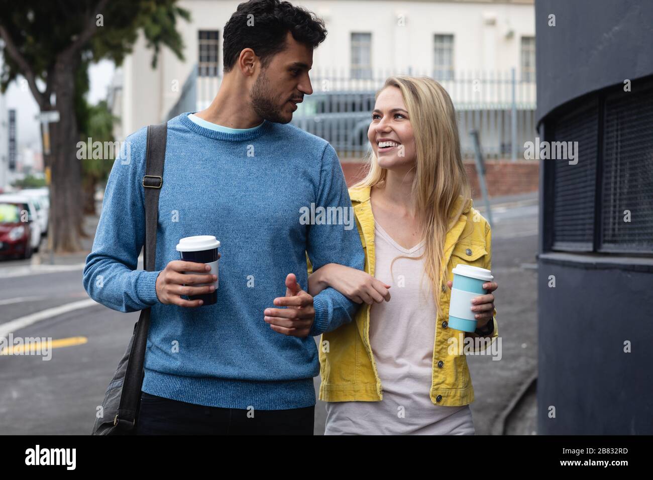 Coppia caucasica in viaggio in città con un caffè da asporto Foto Stock