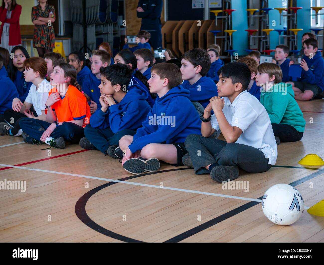 Bambini della scuola principale Davidsons scuola primaria ascoltando una presentazione nella palestra della scuola, Edimburgo, Scozia, Regno Unito Foto Stock