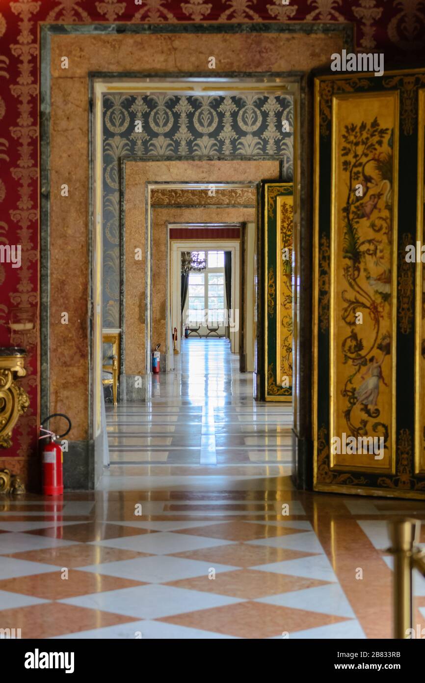 Palazzo reale di Napoli, settembre 2016. La ripetizione delle porte delle molte camere di questo luogo estremamente ricco vista da una persona centrale Foto Stock
