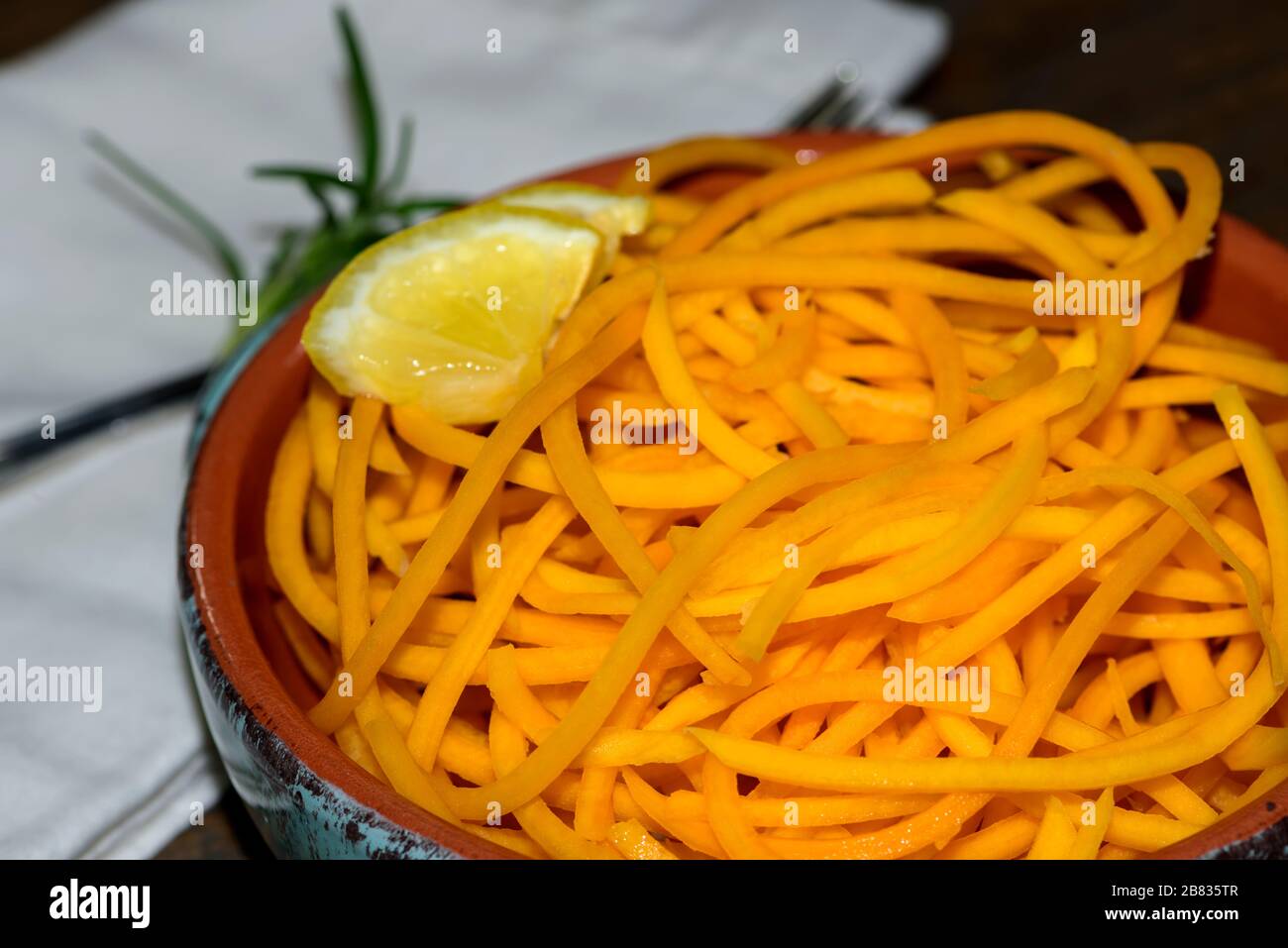 Ciotola di Butternut Squash Noodles fresco con fetta di limone e rametto di rosmarino. Foto Stock