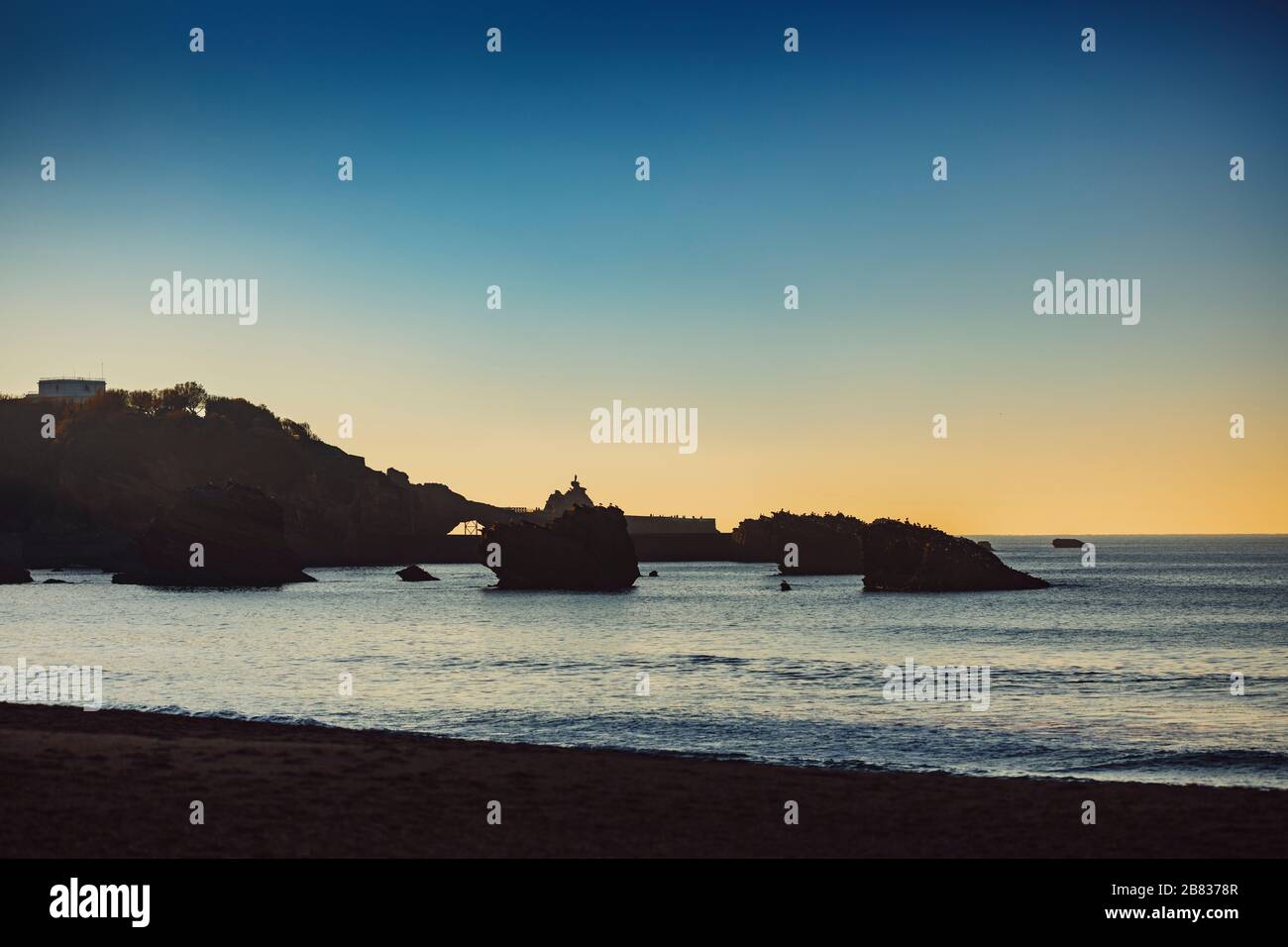 Vista durante il tramonto dell'oceano e Rocher de la Vierge (la Rocca della Vergine Maria) dalla Grande Plage a Biarritz, Francia Paesi Baschi. Foto Stock