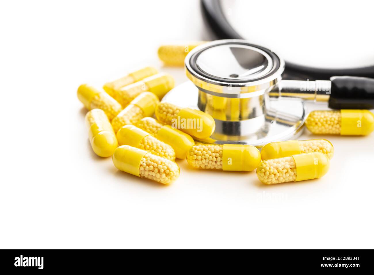 Capsule vitaminiche. Pillole di vitamina C e stetoscopio isolati su sfondo bianco. Foto Stock