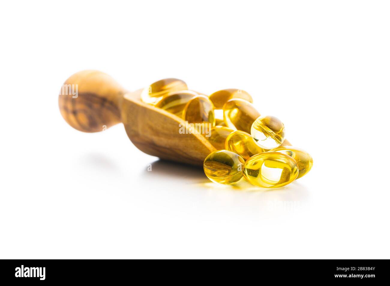 Omega 3 pillole. Capsule di supplemento di olio di pesce in paletta di legno isolato su sfondo bianco. Foto Stock