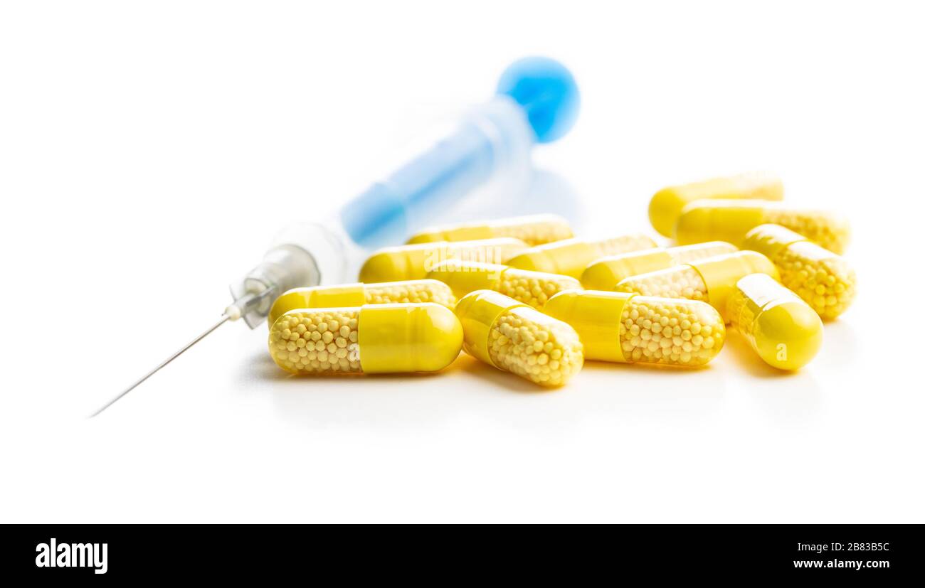 Capsule vitaminiche. Pillole di vitamina C e siringa isolata su sfondo bianco. Foto Stock