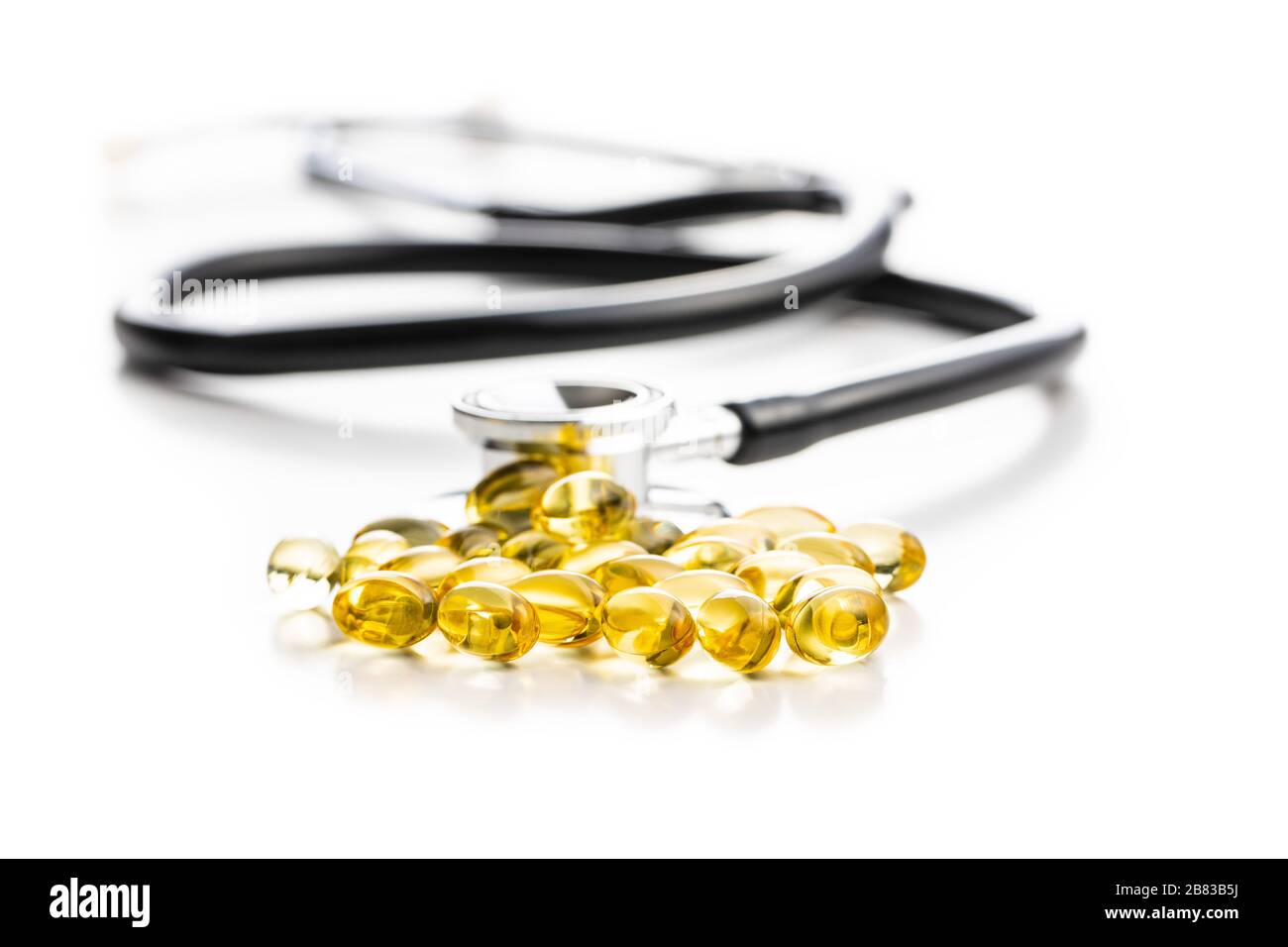 Omega 3 pillole. Capsule di supplemento di olio di pesce e stetoscopio isolati su sfondo bianco. Foto Stock