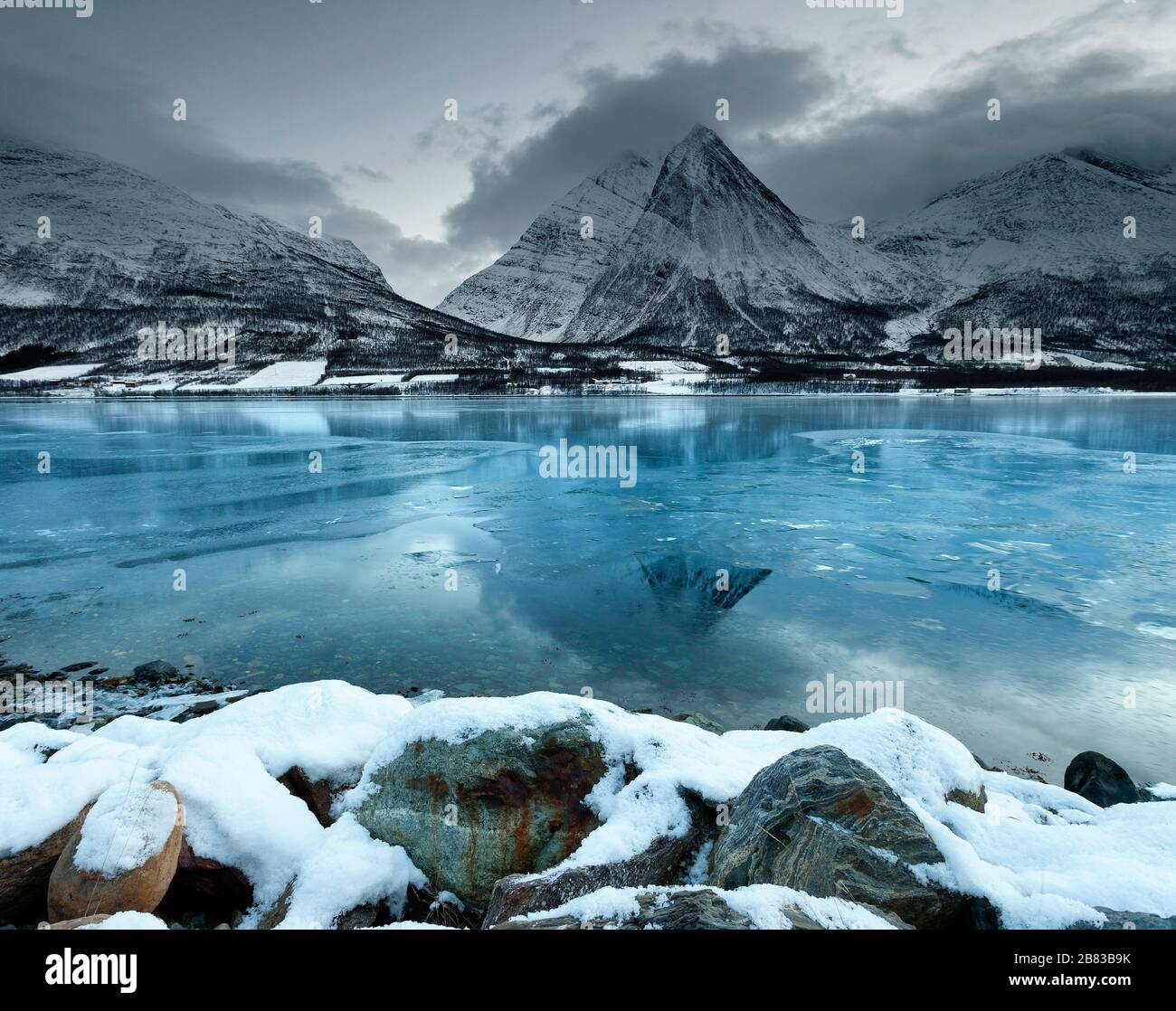 Guardando attraverso il mare ghiacciato di Ullsfjord da Sjursnes, verso il sud delle Alpi Lyngen, al tramonto, Troms, Norvegia, Europa Foto Stock