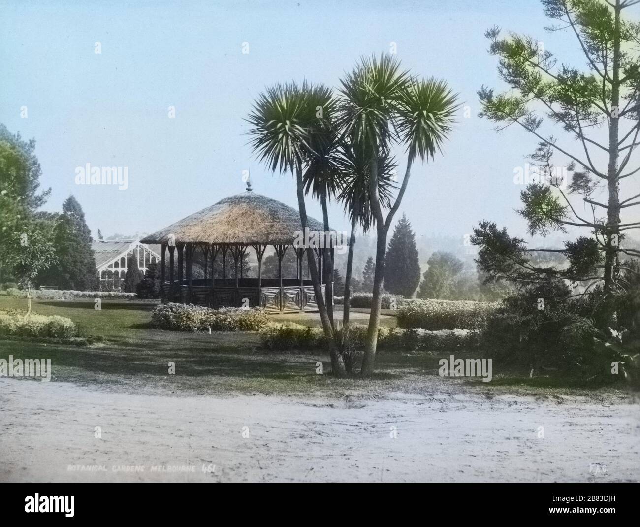 Fotografia di paesaggio bianco e nero di un gazebo con tetto di paglia e alcune palme in primo piano nei Royal Botanic Gardens Victoria a Melbourne, Australia, dal fotografo Frank Coxhead, 1885. Dalla Biblioteca pubblica di New York. Nota: L'immagine è stata colorata digitalmente utilizzando un processo moderno. I colori potrebbero non essere precisi in termini di periodo. () Foto Stock