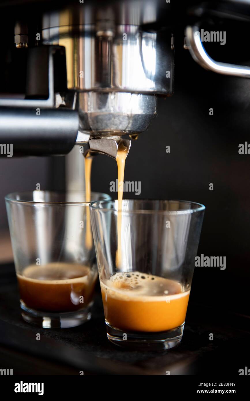 Primo piano di una macchina da caffè che versa il caffè in tazze Foto Stock