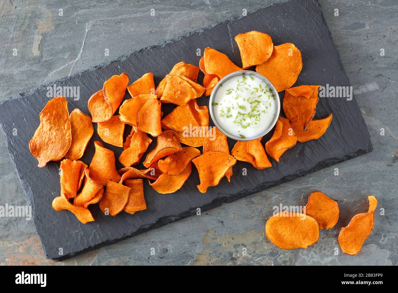 Patatine vegetali sane con immersione, vista dall'alto su un server di pietra e sfondo ardesia Foto Stock