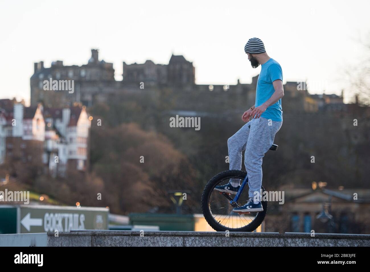 Edimburgo, Regno Unito. 19 Mar 2020. Nella foto: Andrew Buchan, una stunt e un estremo unicista passa il tempo durante quella che normalmente sarebbe un'ora di punta a Edimburgo, ma a causa della pandemia di Coronavirus il centro della città è estremamente tranquillo. La gente ora è affrontata con fare le cose differenti con il loro tempo durante l'isolamento di auto. Lo Scott Monument si trova sullo sfondo, un importante punto di riferimento di Edimburgo. Credit: Colin Fisher/Alamy Live News Foto Stock