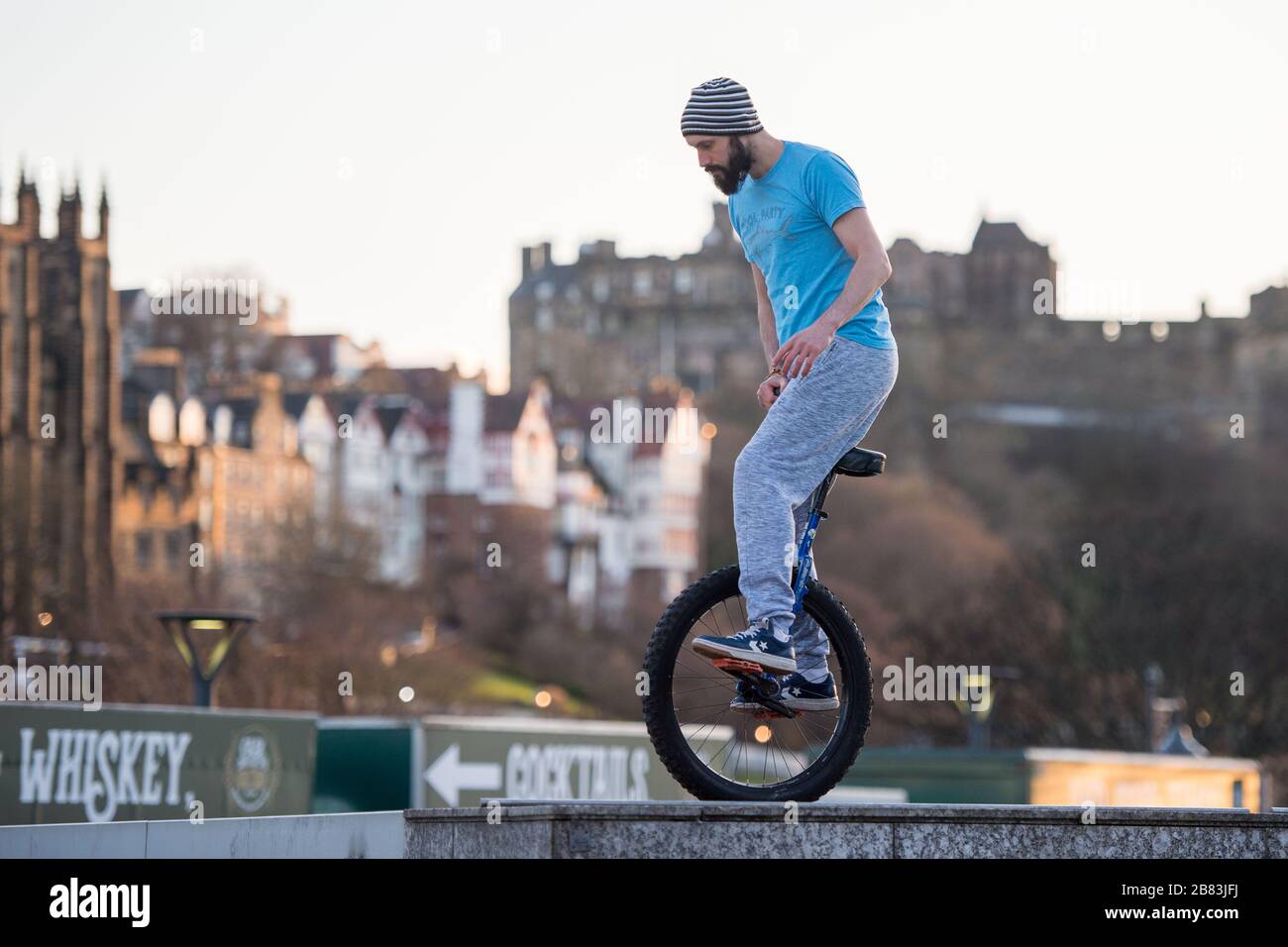 Edimburgo, Regno Unito. 19 Mar 2020. Nella foto: Andrew Buchan, una stunt e un estremo unicista passa il tempo durante quella che normalmente sarebbe un'ora di punta a Edimburgo, ma a causa della pandemia di Coronavirus il centro della città è estremamente tranquillo. La gente ora è affrontata con fare le cose differenti con il loro tempo durante l'isolamento di auto. Lo Scott Monument si trova sullo sfondo, un importante punto di riferimento di Edimburgo. Credit: Colin Fisher/Alamy Live News Foto Stock