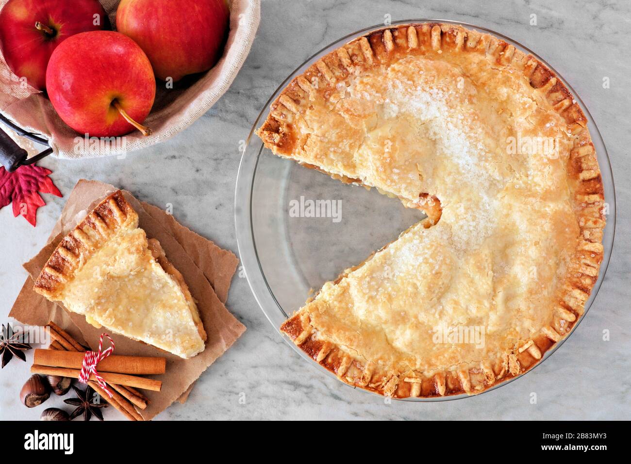 Torta autunnale di mele, scena aerea con fetta tagliata su sfondo di marmo Foto Stock