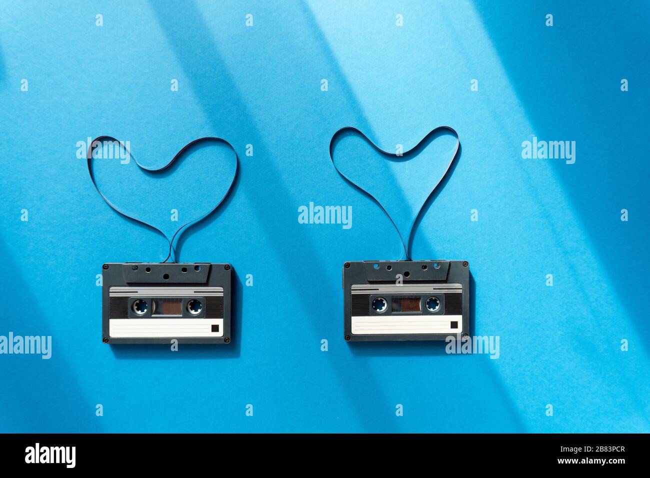 cassette con nastro magnetico a forma di cuore su sfondo blu Foto Stock
