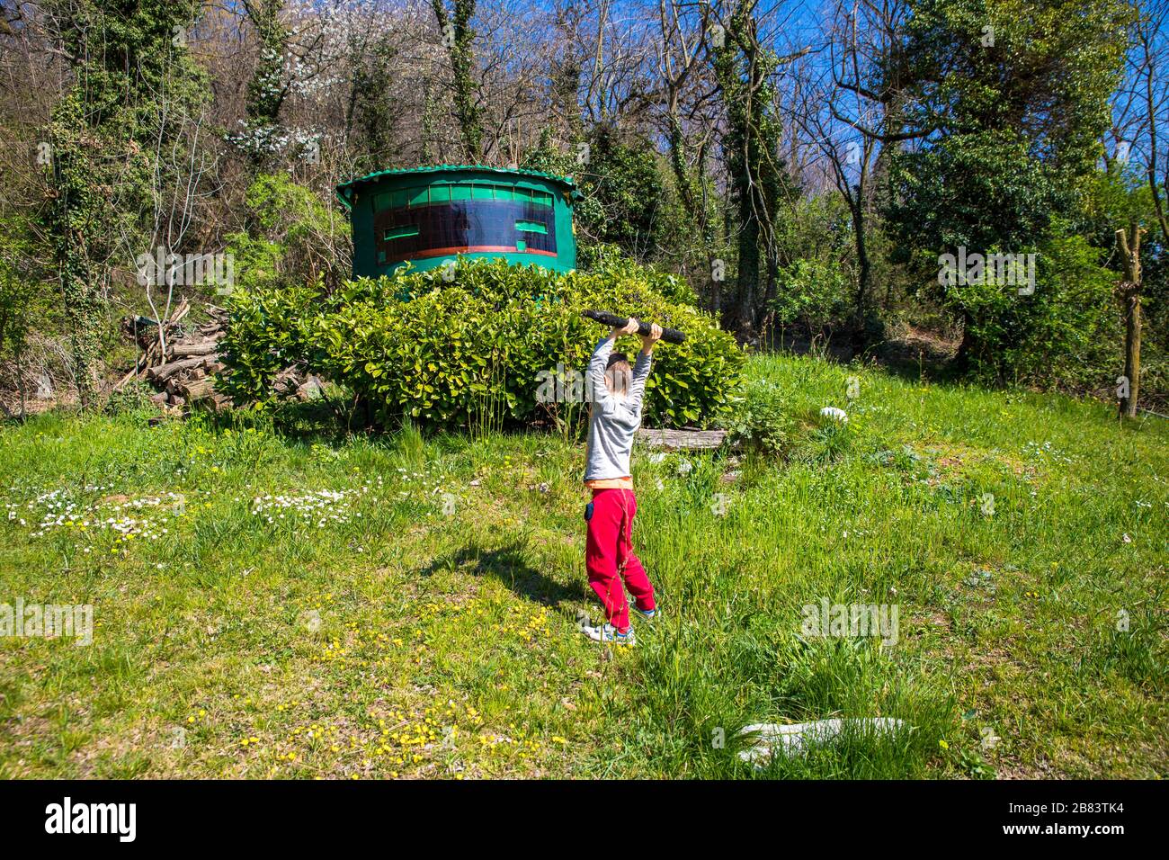 il bambino gioca lanciando un tronco di legno Foto Stock