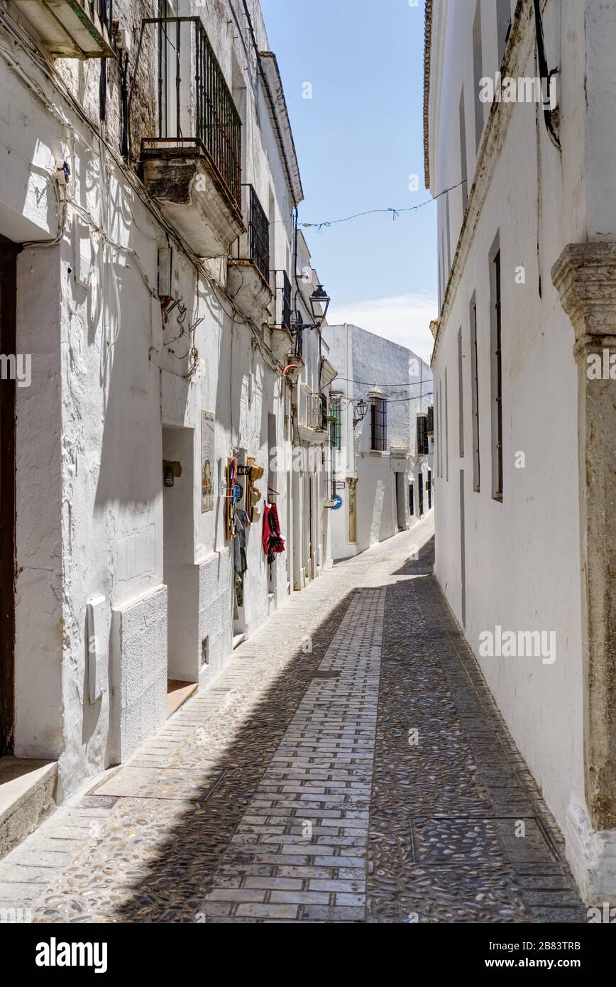 Una delle strette stradine acciottolate dello storico villaggio bianco Arcos de la Frontera, provincia di Cadice, Andalusia (Andalusia). Spagna. Europa Foto Stock