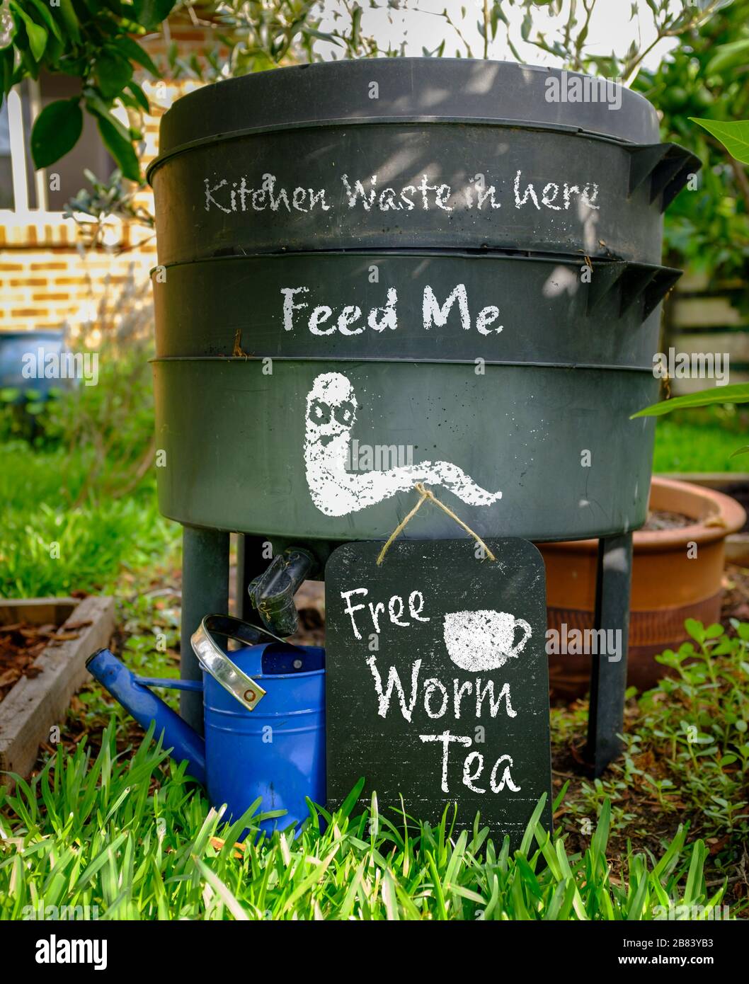 Verme fattoria, wormery, compost bin in giardino biologico con segno per Free Worm Tea, feed me e rifiuti di cucina in qui, vita sostenibile e zero rifiuti li Foto Stock