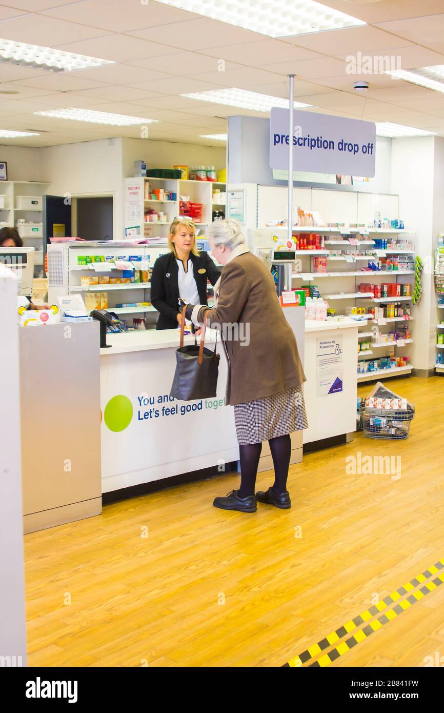 19 marzo 2020 un cliente anziano al punto di pagamento iin Boots Drug Store a Ballyholme Bangor Irlanda del Nord durante le crisi del virus Covid 19 Foto Stock