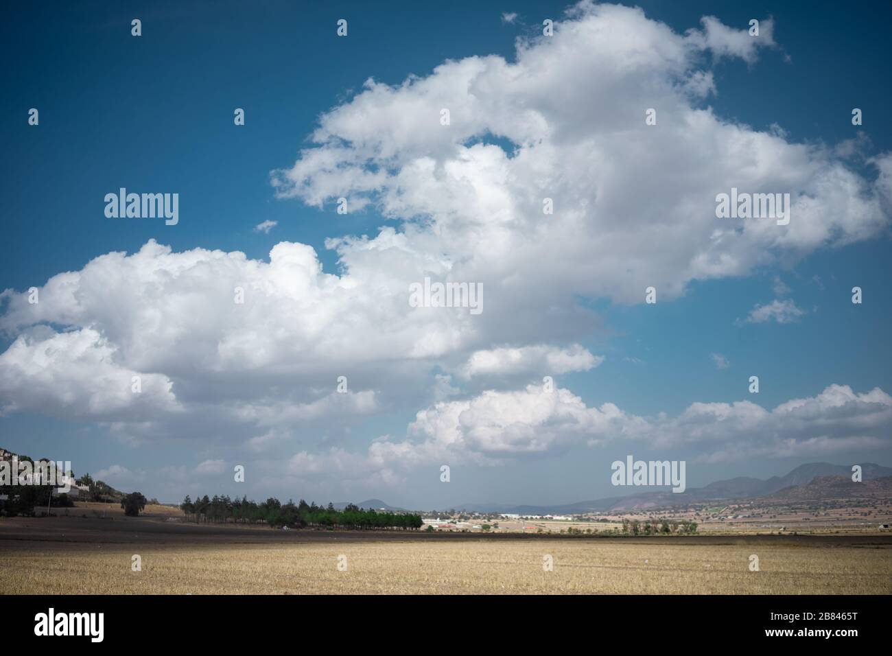 Paesaggio soleggiato con spettacolari nuvole e cielo blu delle pianure dello Stato di Hidalgo Foto Stock