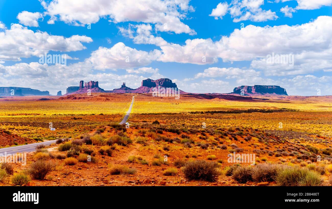 Autostrada 163 che conduce alle torreggianti Mitten Buttes di arenaria e Mesas della Monument Valley della Nazione Navajo al confine tra Utah e Arizona, Stati Uniti Foto Stock