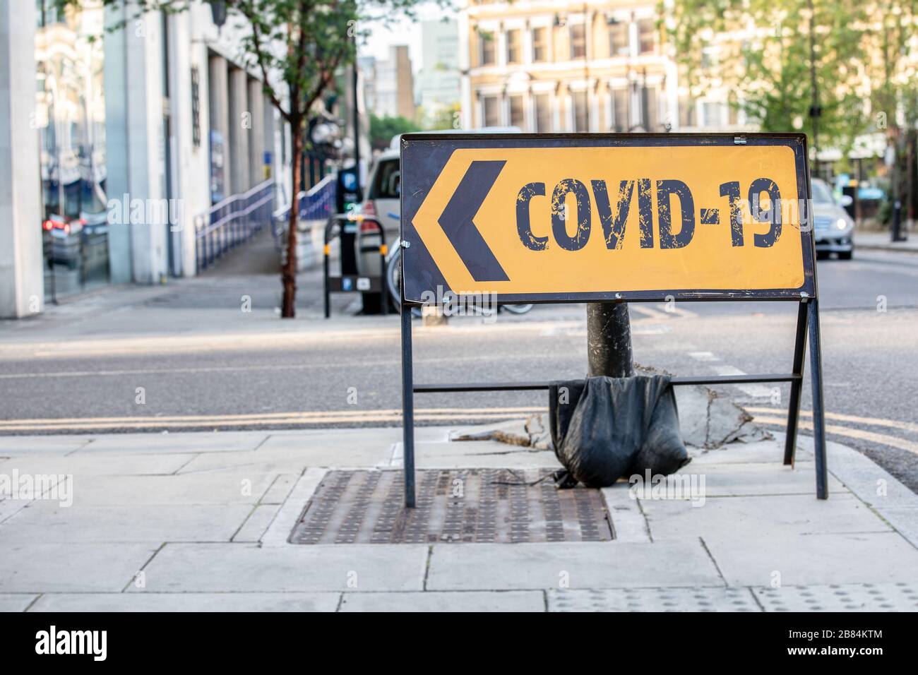 COVID-19 Coronavirus - focolaio di disagio che è stato segnalato per la prima volta da Wuhan, Cina. Cartello stradale diversione giallo in una strada della città del Regno Unito Foto Stock