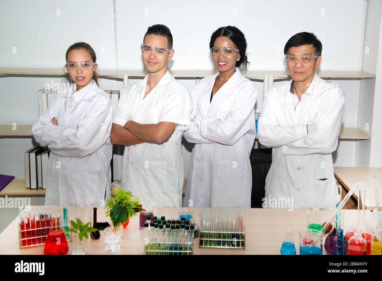 Gruppo sorridente di scienziati in laboratorio moderno , squadra mista di ricercatori scientifici in laboratorio indossando camici bianchi. Foto Stock