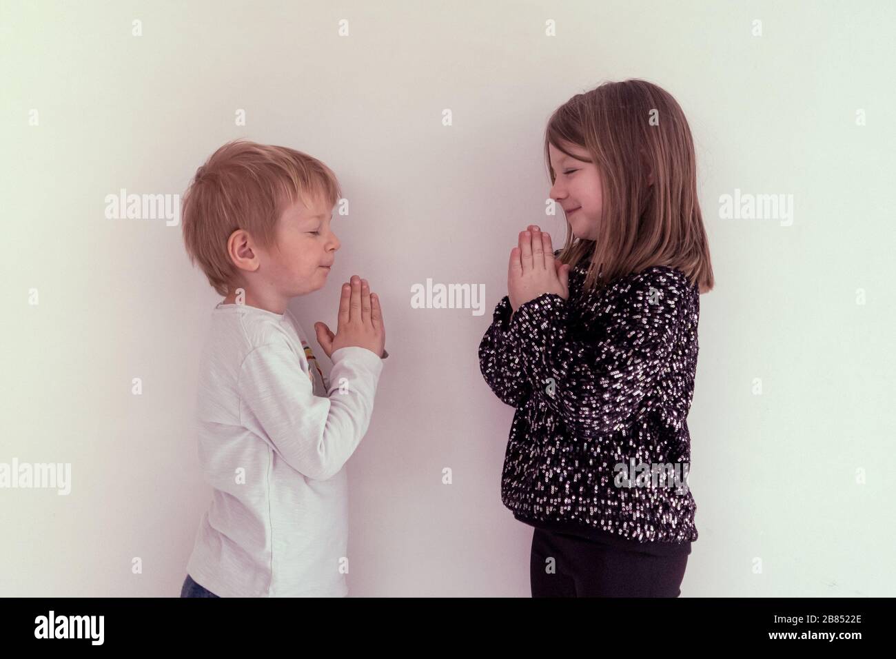 bambini che eseguono saluti namaste in tempo di scoppio di pandemia di coronavirus Foto Stock