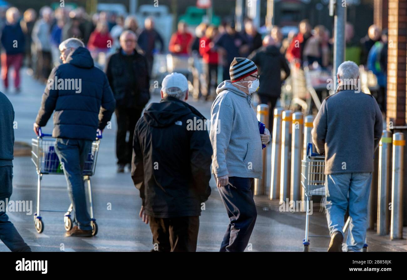 I clienti si riuniscono all'esterno del negozio Tesco di Mather Avenue, Liverpool, prima dell'apertura dell'IT. Foto Stock