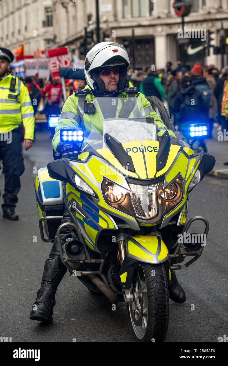 Ufficiale motociclistico della polizia metropolitana, che garantisce la sicurezza stradale e il controllo della folla, mentre è in servizio durante la manifestazione Million Women Rise. Foto Stock