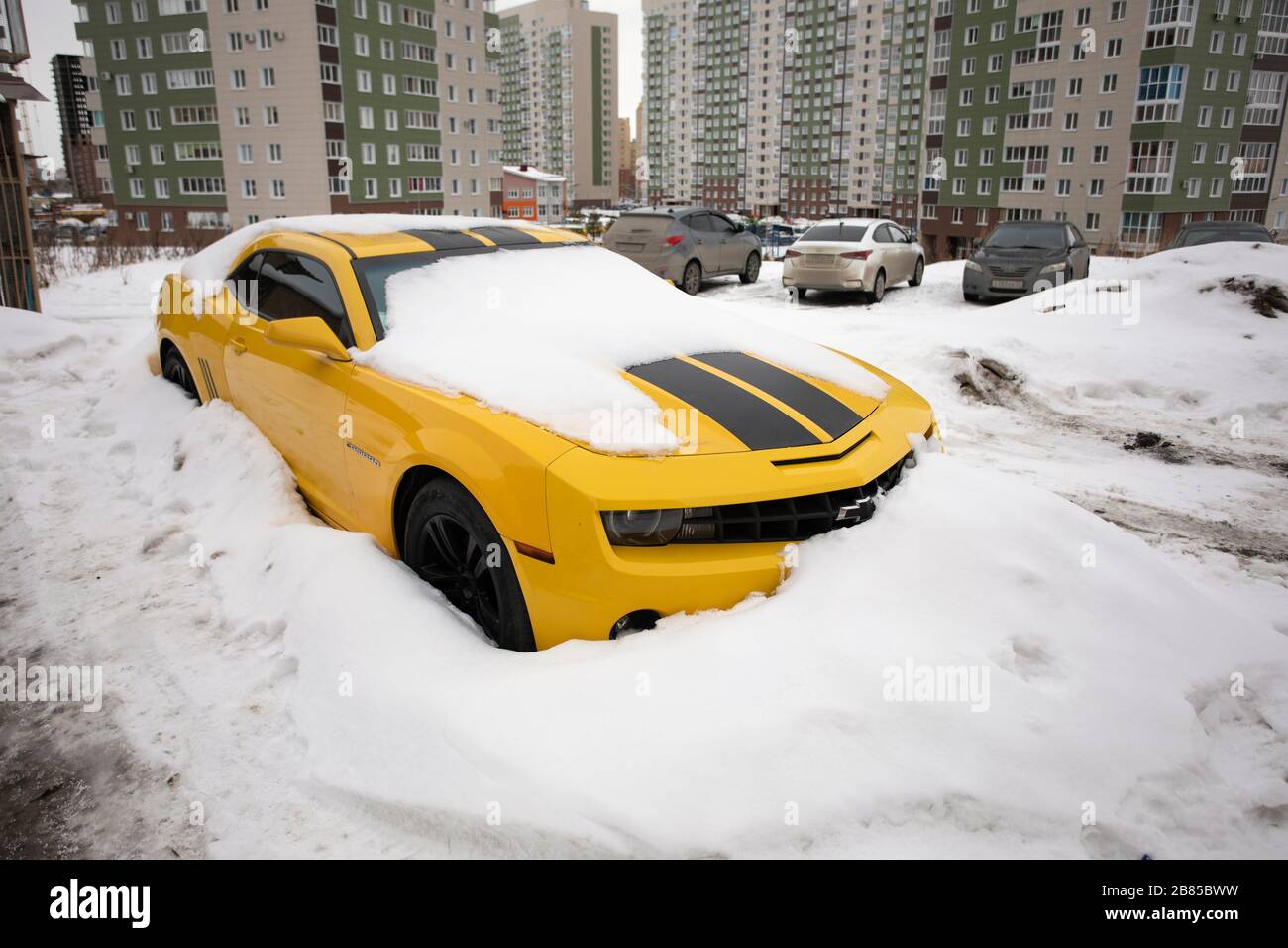 Giallo Chevrolet Camaro con strisce nere in piedi al parcheggio in inverno. Omsk, Russia, 29.02.2020 Foto Stock