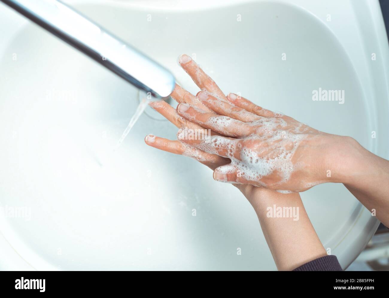 Lavare le mani con sapone sotto acqua. Foto Stock