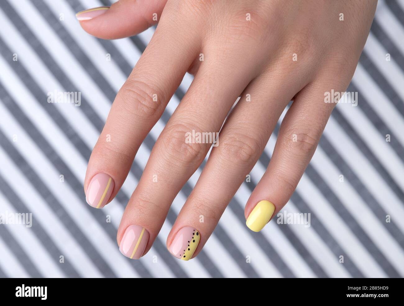 Le mani della donna con disegno del chiodo di estate della molla Foto Stock