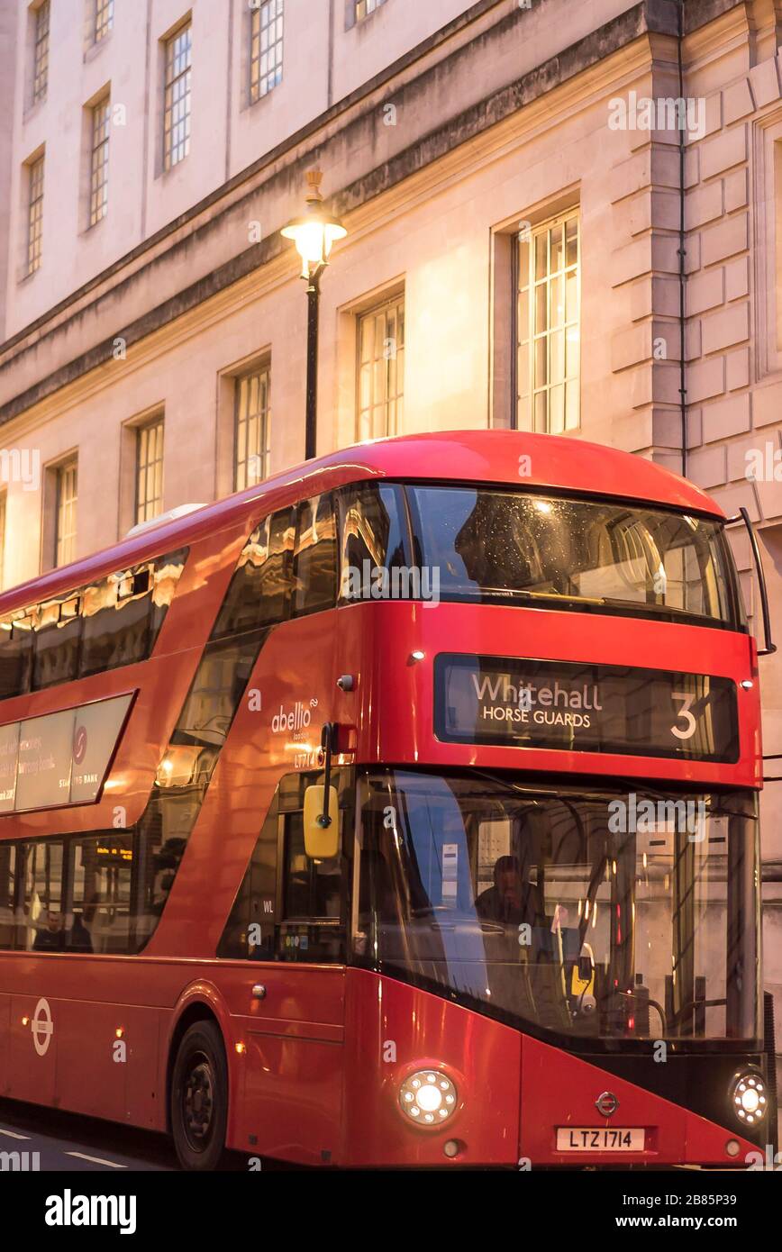 Vista frontale del grande autobus rosso a due piani di Londra, parcheggiato in uno stand autobus nel centro di Londra strada, la sera. Trasporto pubblico in autobus, Whitehall, Regno Unito. Foto Stock