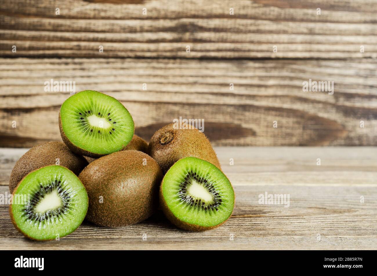 tagliare il kiwi piegato in un mucchio su uno sfondo di legno Foto Stock