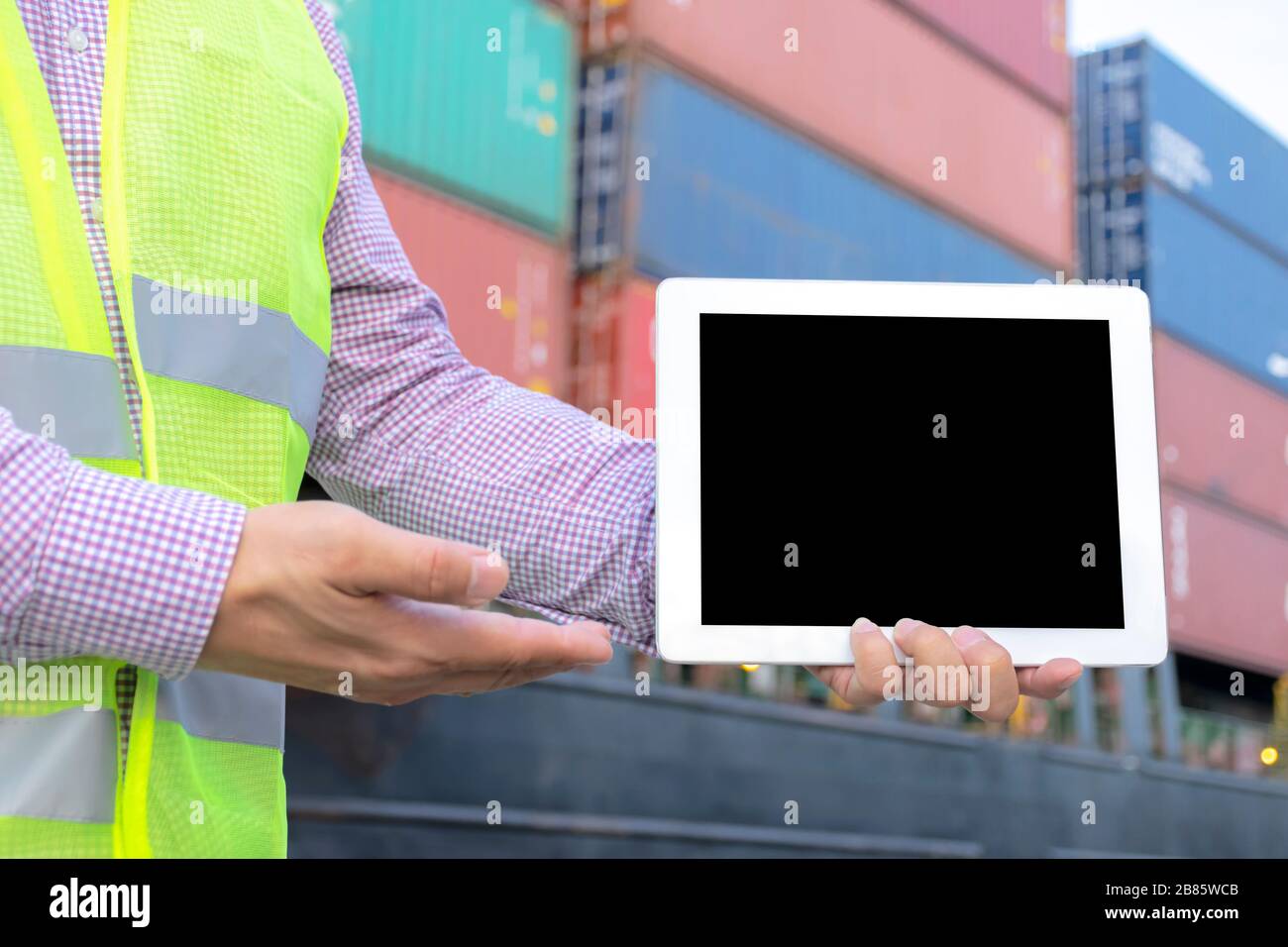 Concetto logistico. L'ingegneria sta tenendo un tablet. Spazio libero per poter inserire testo o immagini per creare un media pubblicitario. Lo sfondo è un l Foto Stock