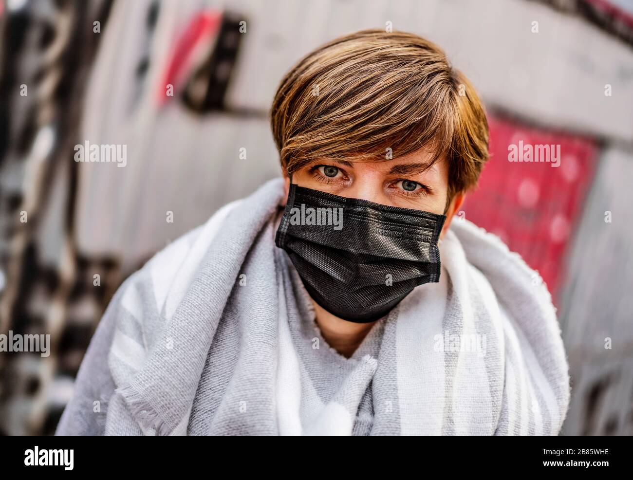 Una donna che indossa una maschera facciale cammina su una strada durante l'epidemia di coronavirus (COVID-19) a Praga, giovedì 19 marzo 2020. (Foto CTK/René FLUGER) Foto Stock