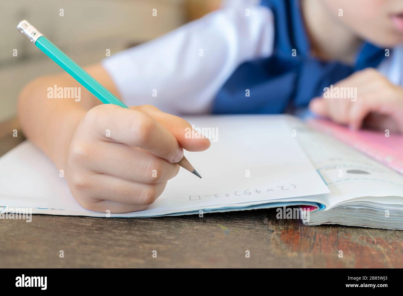 Gli studenti che tengono matite per il calcolo della matematica, seduti in classe sono interessati alla matematica. Allenamenti frequenti contribuiranno ad aumentare lo sci Foto Stock